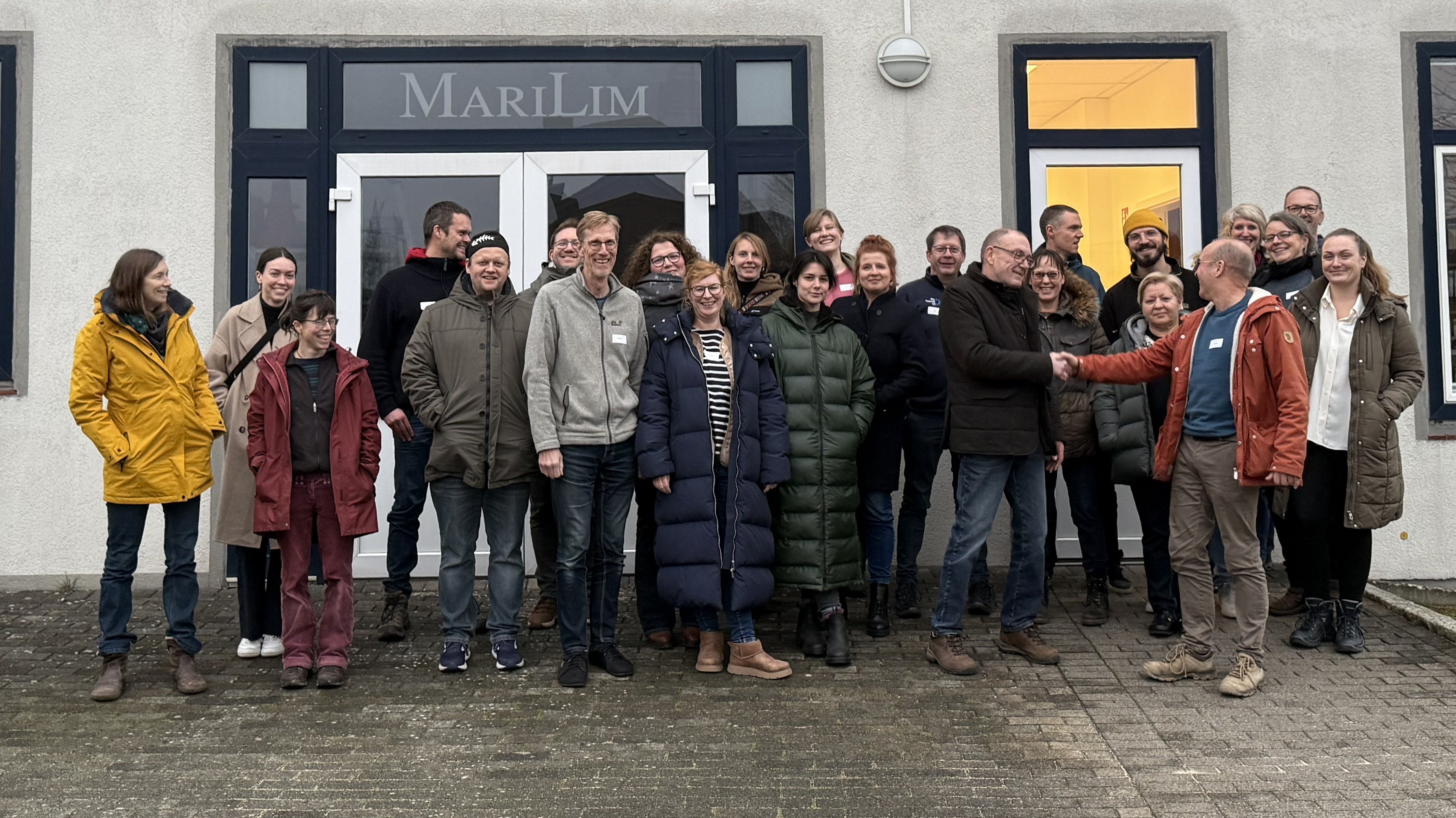 Mitarbeitende von MariLim und BioConsult SH vor dem Gebäude von MariLim in Kiel.  Georg Nehls, Geschäftsführer von BioConsult SH, heißt Thomas Meyer, Gründer und Geschäftsführer von MariLim, und sein Team in der BioConsult SH Gruppe herzlich willkommen. 