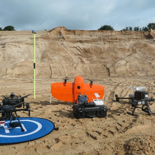 Different types of drones next to each other in a gravel pit.