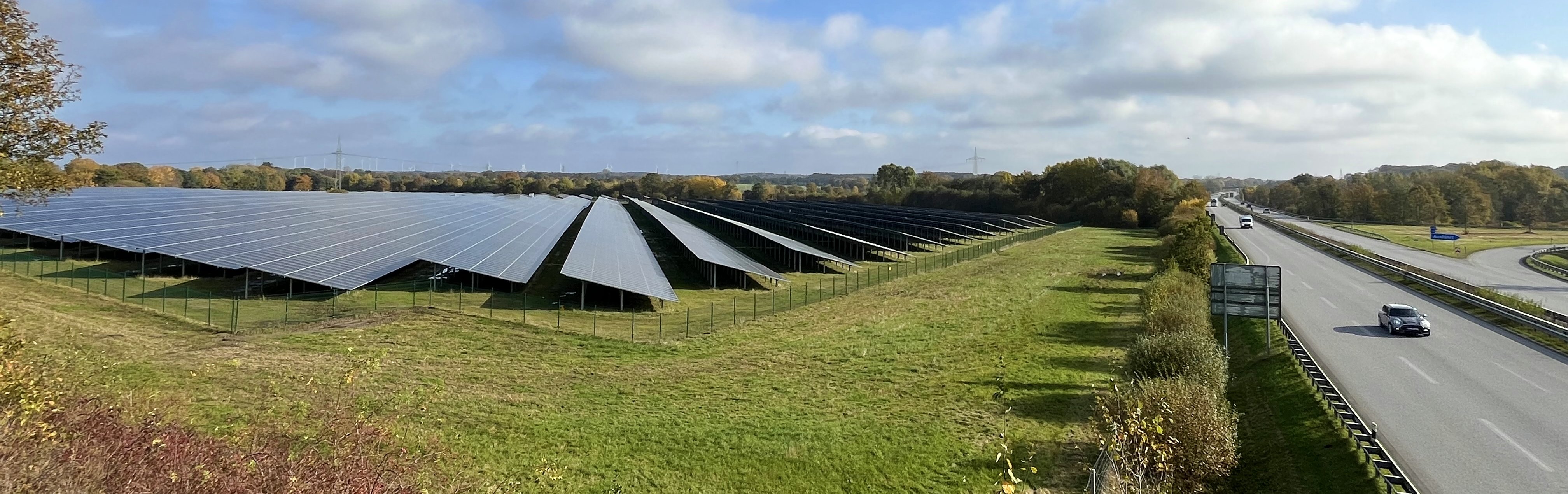 Foto eines Solarparks an einer Autobahn.